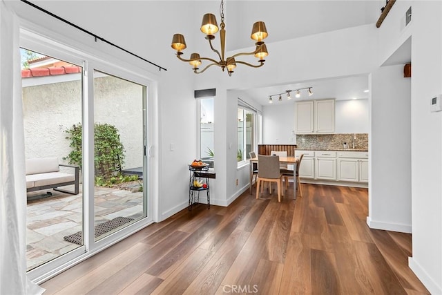 dining room with plenty of natural light, dark hardwood / wood-style floors, sink, and a notable chandelier