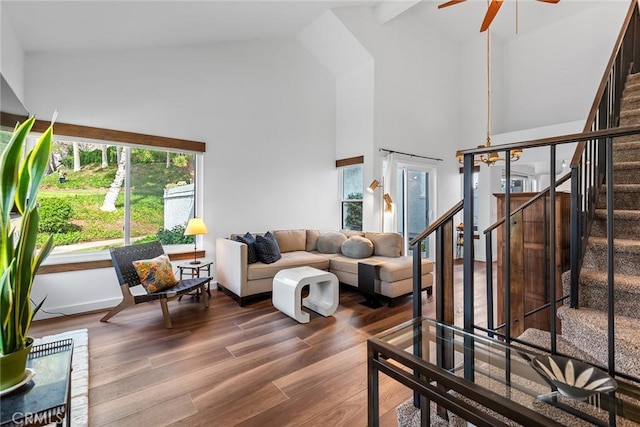 living room with hardwood / wood-style flooring, ceiling fan, and high vaulted ceiling