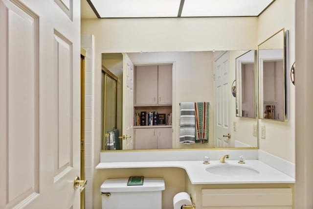 bathroom with an enclosed shower, vanity, and toilet