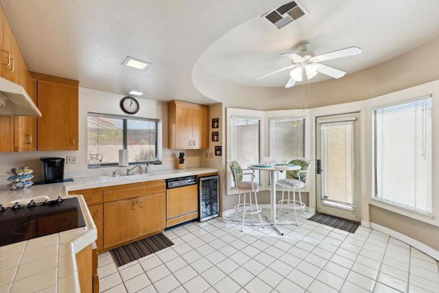 kitchen with light tile patterned flooring, tile countertops, sink, wine cooler, and dishwashing machine