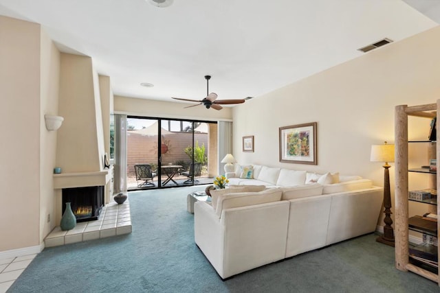 carpeted living room featuring ceiling fan and a fireplace