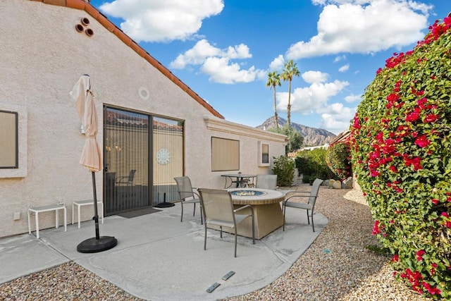 view of patio with a mountain view and a fire pit