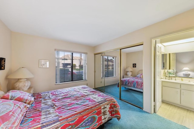 carpeted bedroom with ensuite bathroom and a closet