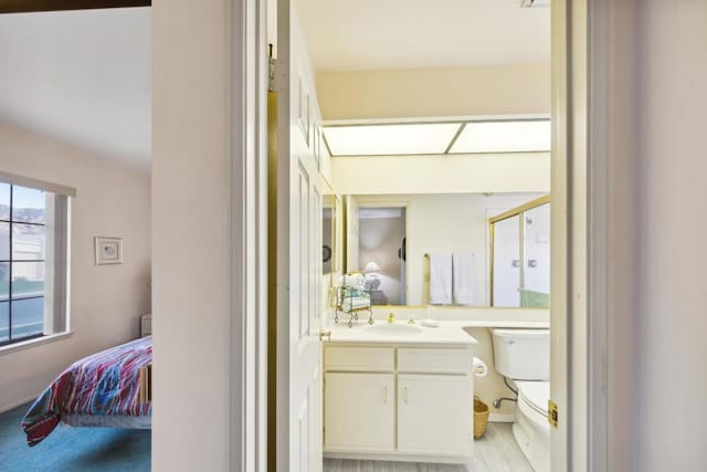 bathroom with vanity, a shower with shower door, and toilet