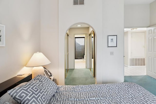 bedroom with a high ceiling and carpet