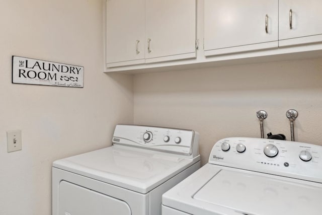 clothes washing area featuring cabinets and independent washer and dryer