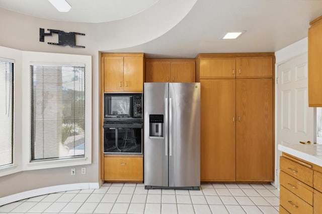 kitchen with light tile patterned flooring and black appliances