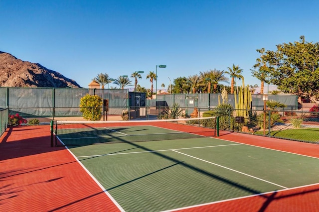 view of sport court with a mountain view and basketball hoop