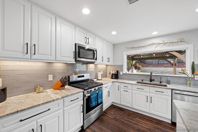 kitchen featuring white cabinetry, appliances with stainless steel finishes, dark hardwood / wood-style flooring, and sink