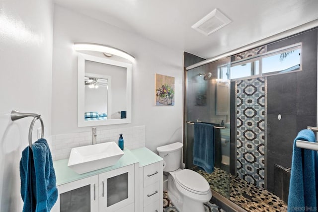 bathroom with vanity, decorative backsplash, toilet, and walk in shower