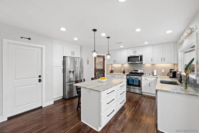 kitchen featuring sink, stainless steel appliances, white cabinets, and a kitchen island