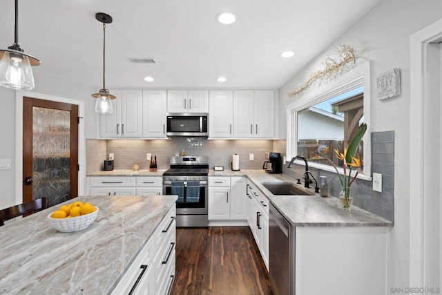 kitchen with white cabinetry, sink, decorative light fixtures, and stainless steel appliances