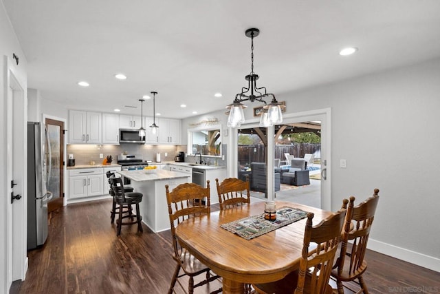 dining space with dark hardwood / wood-style floors and sink