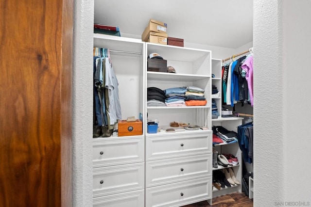 walk in closet with dark hardwood / wood-style floors