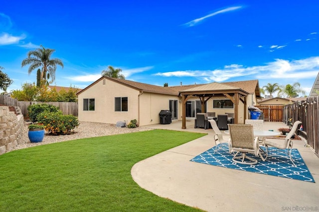 back of property featuring a gazebo, a lawn, and a patio area