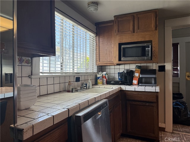 1490 W 51st St, Los Angeles, CA 90062 - kitchen featuring stainless steel appliances, tile counters, and decorative backsplash