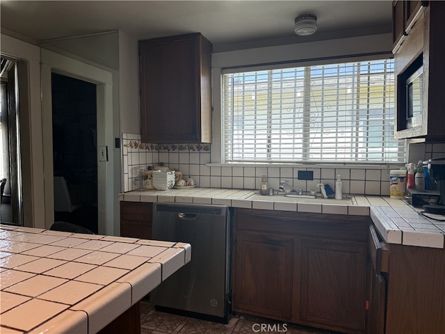 1490 W 51st St, Los Angeles, CA 90062 - kitchen with stainless steel dishwasher, tile counters, and backsplash