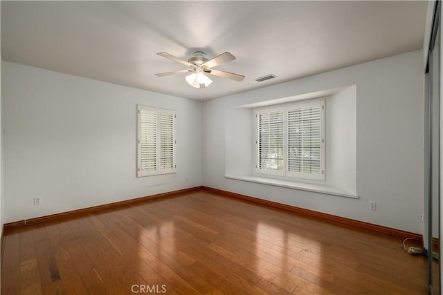 empty room with wood-type flooring and ceiling fan