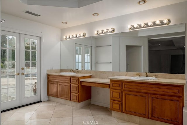 bathroom with tile patterned flooring, vanity, and french doors