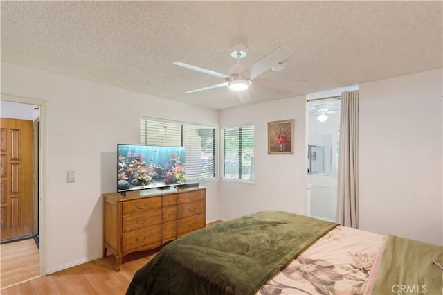 bedroom featuring light wood-style floors, ceiling fan, a textured ceiling, and baseboards