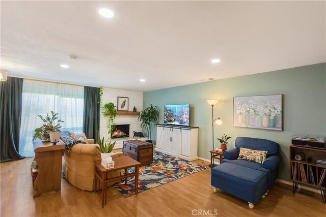 living room with hardwood / wood-style flooring and a fireplace