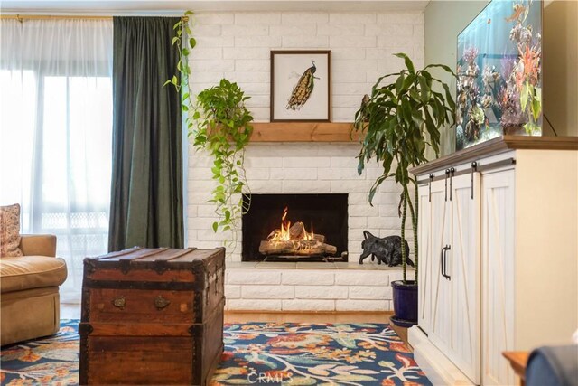 living area featuring a brick fireplace