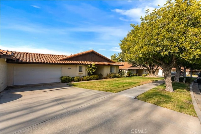 view of front of property featuring a tile roof, stucco siding, a garage, driveway, and a front lawn