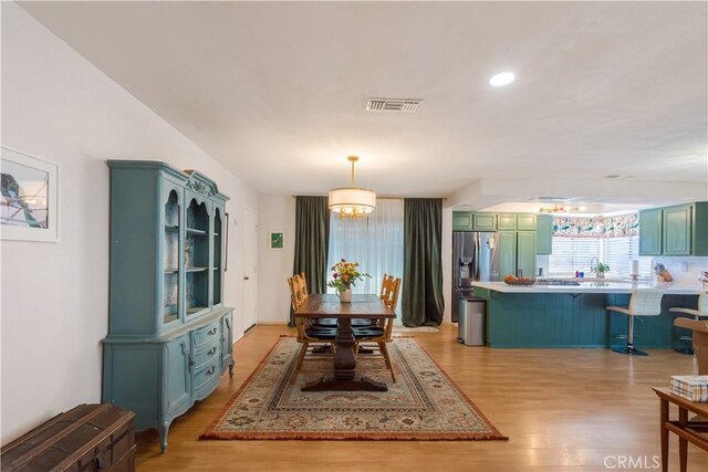 dining space featuring an inviting chandelier and light hardwood / wood-style flooring