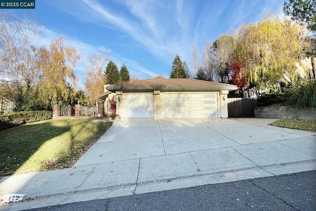 single story home featuring a garage and a front yard