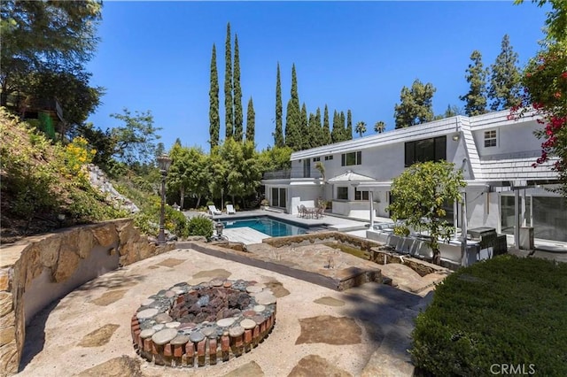 view of pool with a fire pit and a patio area