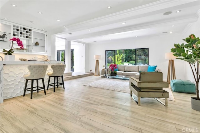 living room with crown molding, light hardwood / wood-style floors, and a wealth of natural light