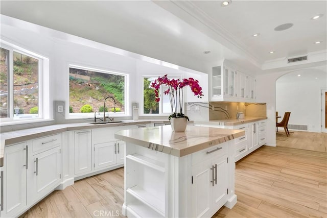 kitchen featuring sink, light hardwood / wood-style flooring, and white cabinets