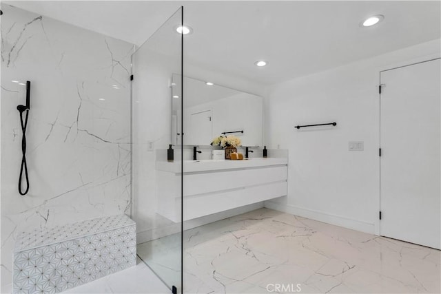 bathroom with a tile shower and vanity