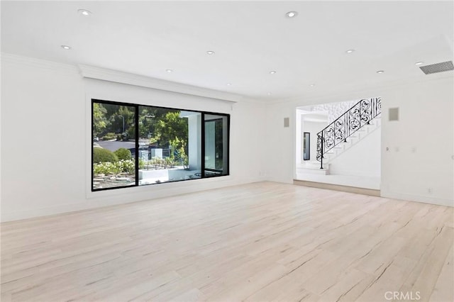 unfurnished living room with crown molding and light hardwood / wood-style floors