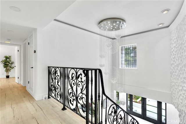 hallway featuring french doors, light hardwood / wood-style flooring, and a notable chandelier