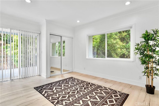 interior space with ornamental molding and light hardwood / wood-style flooring