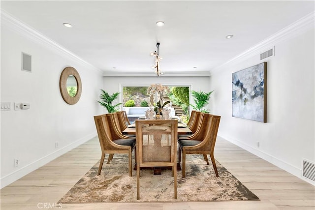 dining room with crown molding and light hardwood / wood-style flooring