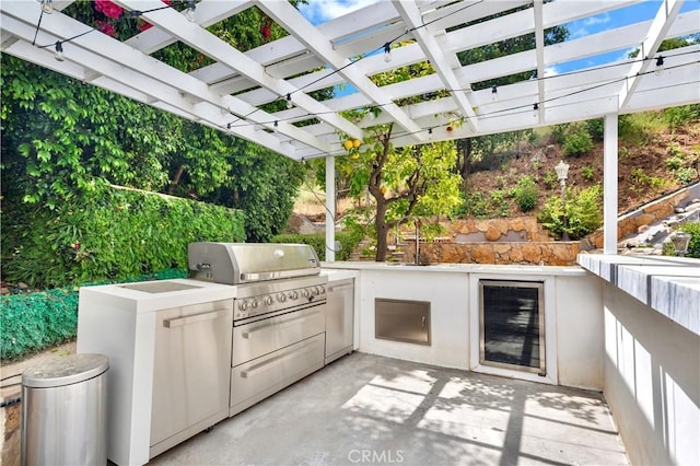 view of patio featuring wine cooler, sink, a pergola, and an outdoor kitchen