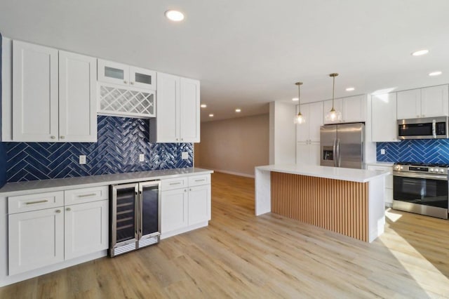 kitchen with pendant lighting, white cabinetry, wine cooler, a center island, and stainless steel appliances