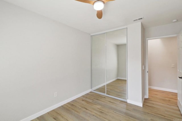 unfurnished bedroom with ceiling fan, light hardwood / wood-style floors, and a closet