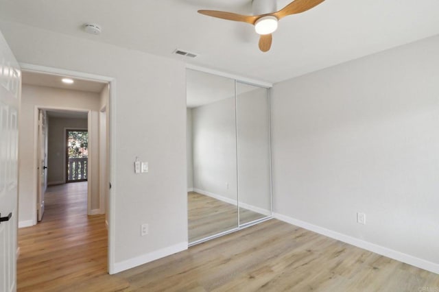 unfurnished bedroom featuring ceiling fan, a closet, and light wood-type flooring