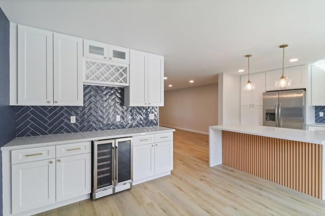 kitchen featuring wine cooler, pendant lighting, white cabinetry, and stainless steel refrigerator with ice dispenser