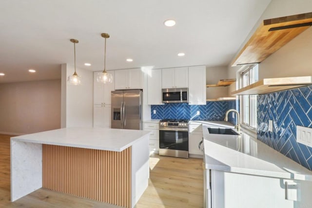 kitchen featuring light wood-style flooring, a sink, open shelves, stainless steel appliances, and white cabinets