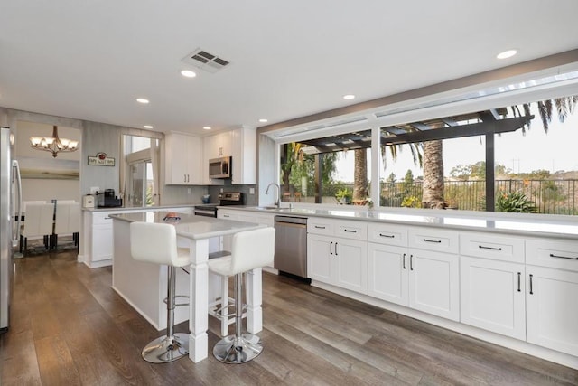 kitchen featuring stainless steel appliances, a kitchen island, and white cabinets