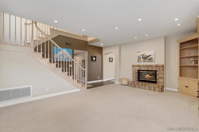 unfurnished living room with a brick fireplace and light carpet