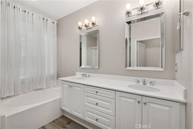 bathroom with tiled shower / bath combo, vanity, and hardwood / wood-style flooring