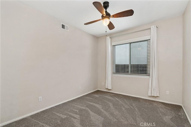 spare room with ceiling fan and dark carpet