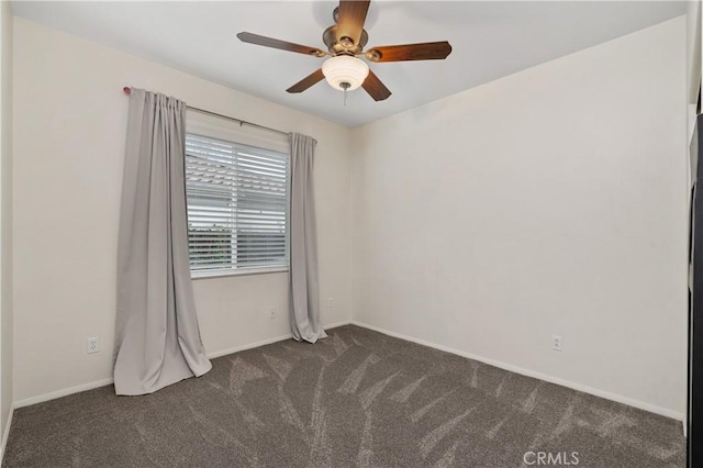 spare room with ceiling fan and dark colored carpet