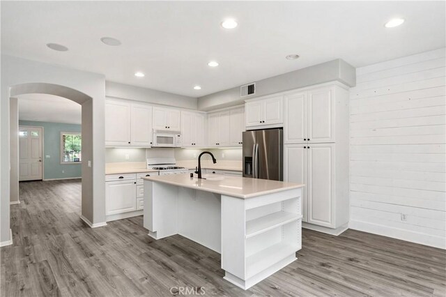 kitchen with white cabinetry, an island with sink, and stainless steel refrigerator with ice dispenser