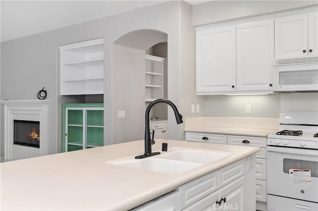 kitchen featuring white cabinetry, sink, and white appliances